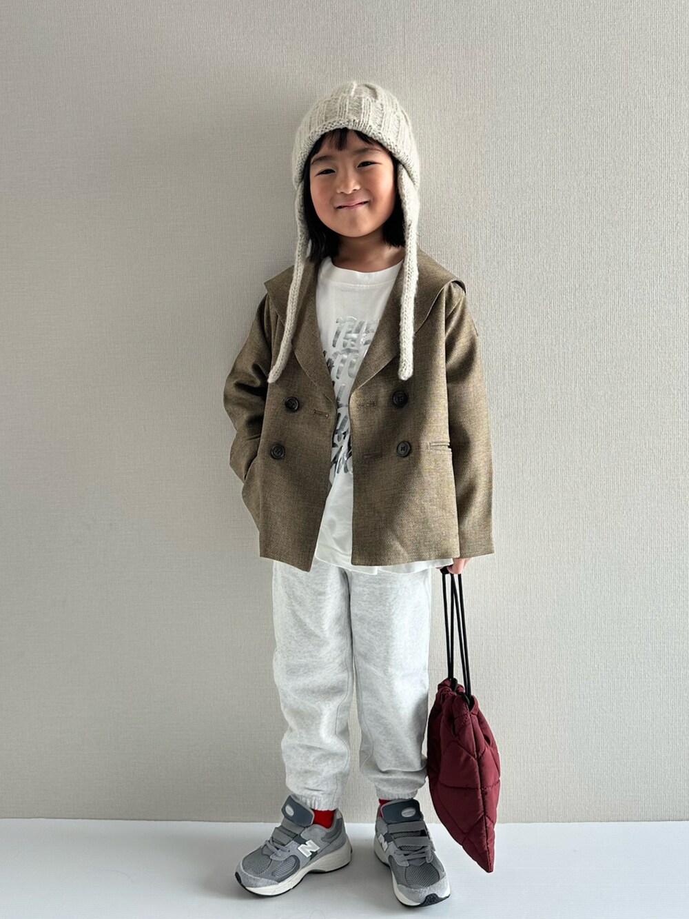 ブラウン系のテーラードジャケット、ホワイト系のTシャツ/カットソー、グレー系のスウェットパンツを着用したキッズの冬コーディネートの5枚目の写真