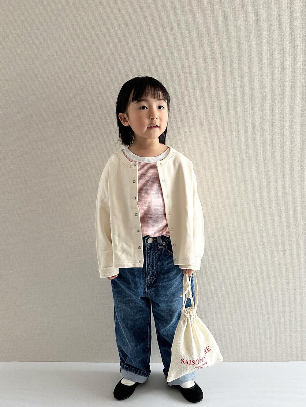 レッド系のトップス、ブルー系のデニムパンツ、ブラック系のその他シューズを着用したキッズの春コーディネートの3枚目の写真