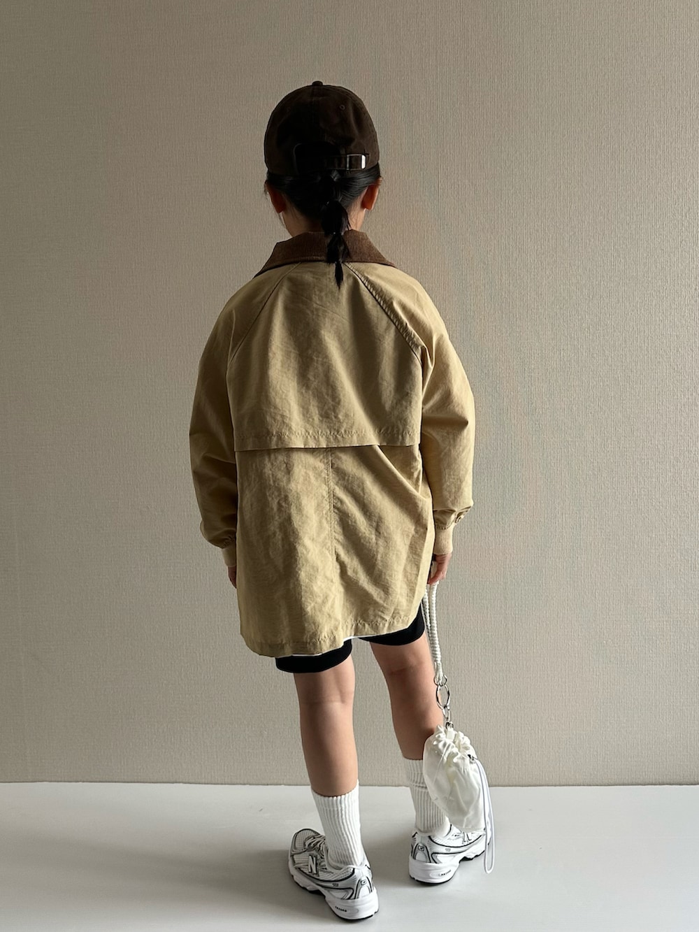 ベージュ系のナイロンジャケット、ホワイト系のTシャツ/カットソー、ブラック系のその他パンツを着用したキッズの春コーディネートの3枚目の写真