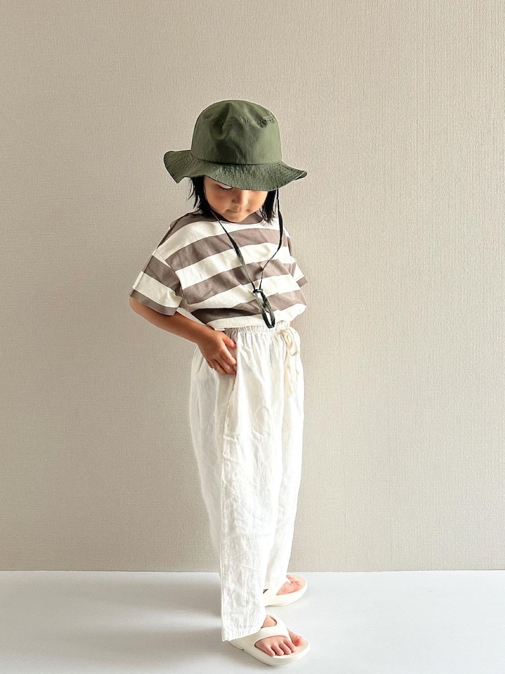 ブラウン系のTシャツ/カットソー、ホワイト系のパンツ、ホワイト系のサンダルを着用したキッズの夏コーディネートの2枚目の写真