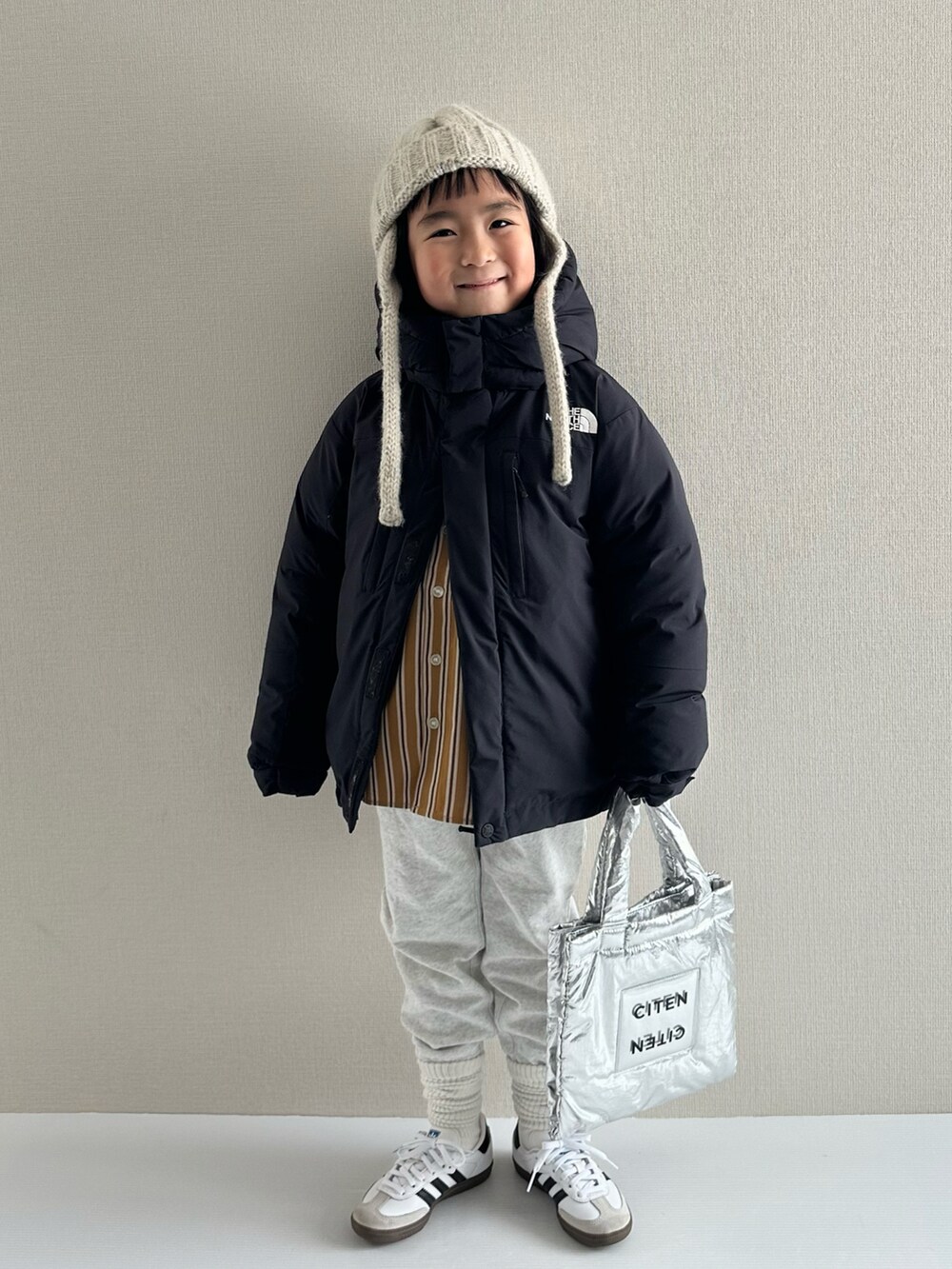 ブラック系のダウンジャケット/コート、イエロー系のシャツ/ブラウス、グレー系のスウェットパンツを着用したキッズの冬コーディネートの5枚目の写真