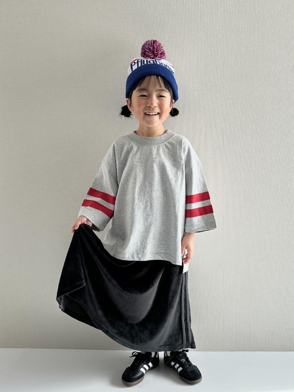 グレー系のTシャツ/カットソー、ブラック系のスカート、ブラック系のスニーカーを着用したキッズの冬コーディネートの4枚目の写真