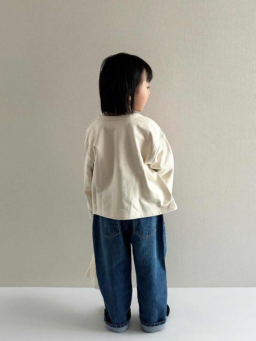 レッド系のトップス、ブルー系のデニムパンツ、ブラック系のその他シューズを着用したキッズの春コーディネートの5枚目の写真