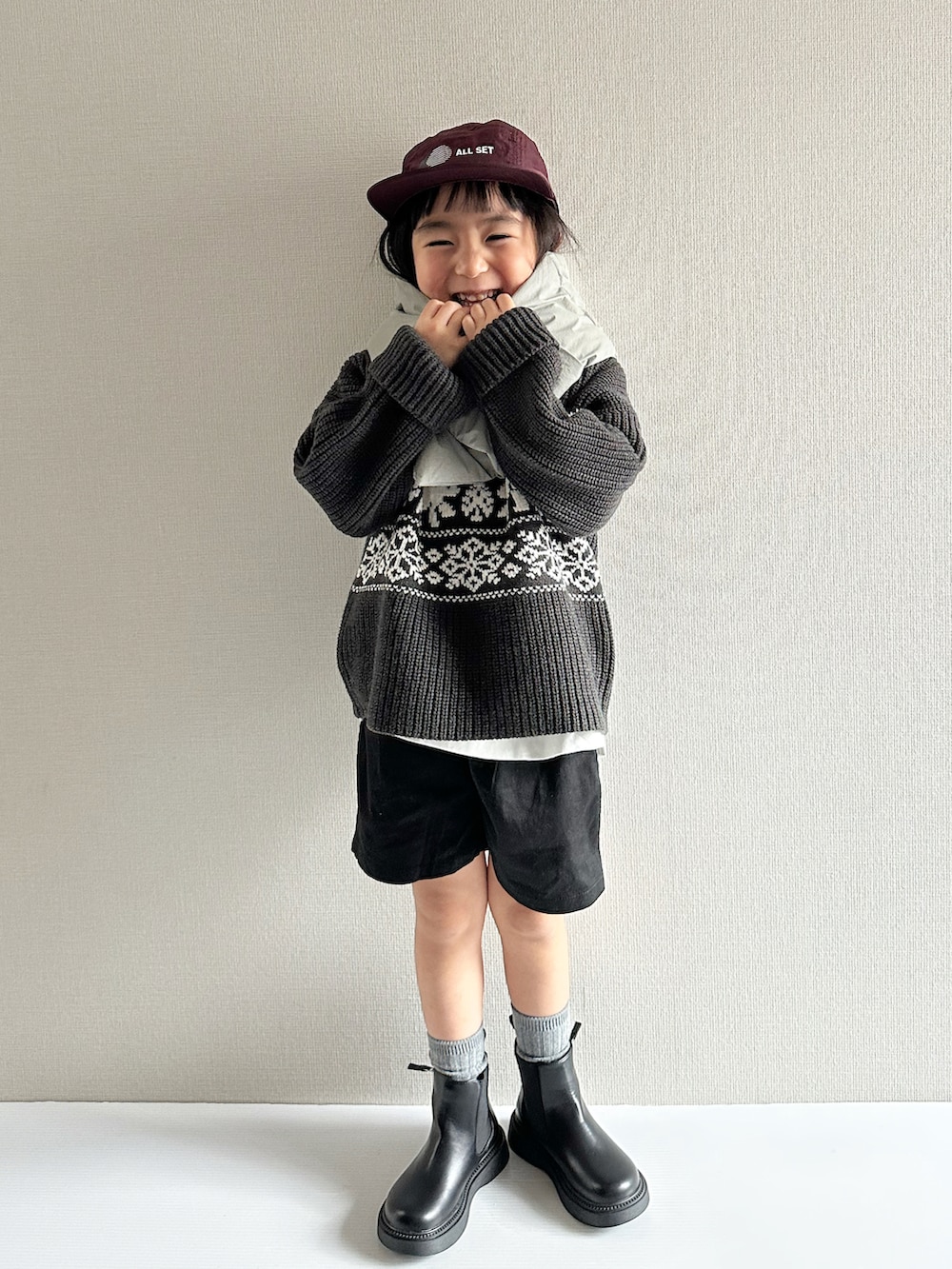 グレー系のニット/セーター、ブラック系のその他パンツ、ブラック系のブーツを着用したキッズの秋コーディネートの3枚目の写真