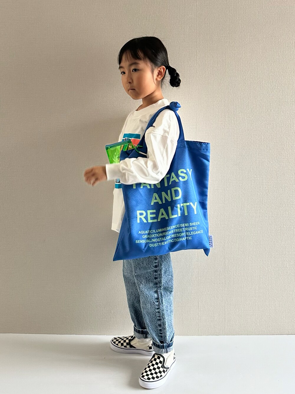 ホワイト系のTシャツ/カットソー、ブルー系のデニムパンツ、ブルー系のトートバッグを着用したキッズの秋コーディネートの2枚目の写真