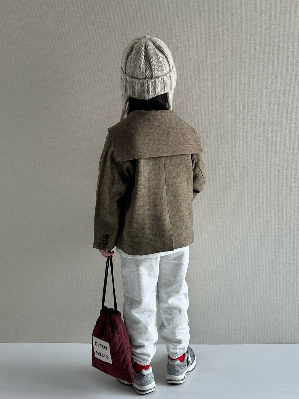 ブラウン系のテーラードジャケット、ホワイト系のTシャツ/カットソー、グレー系のスウェットパンツを着用したキッズの冬コーディネートの3枚目の写真