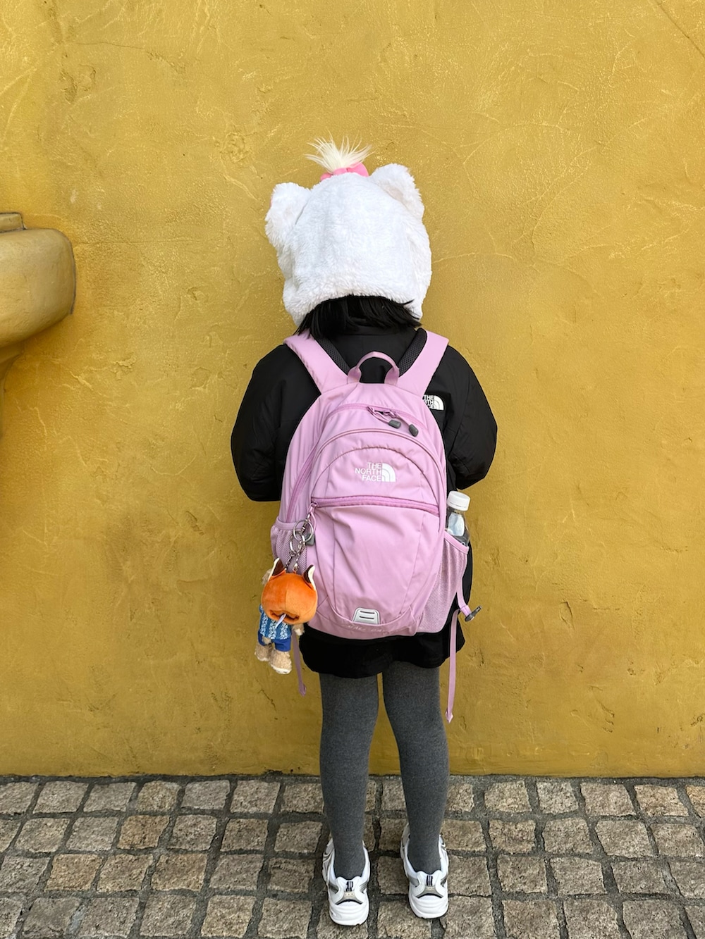 ブラック系のブルゾン、パープル系のバックパック/リュック、ブラック系のスカートを着用したキッズの冬コーディネートの3枚目の写真