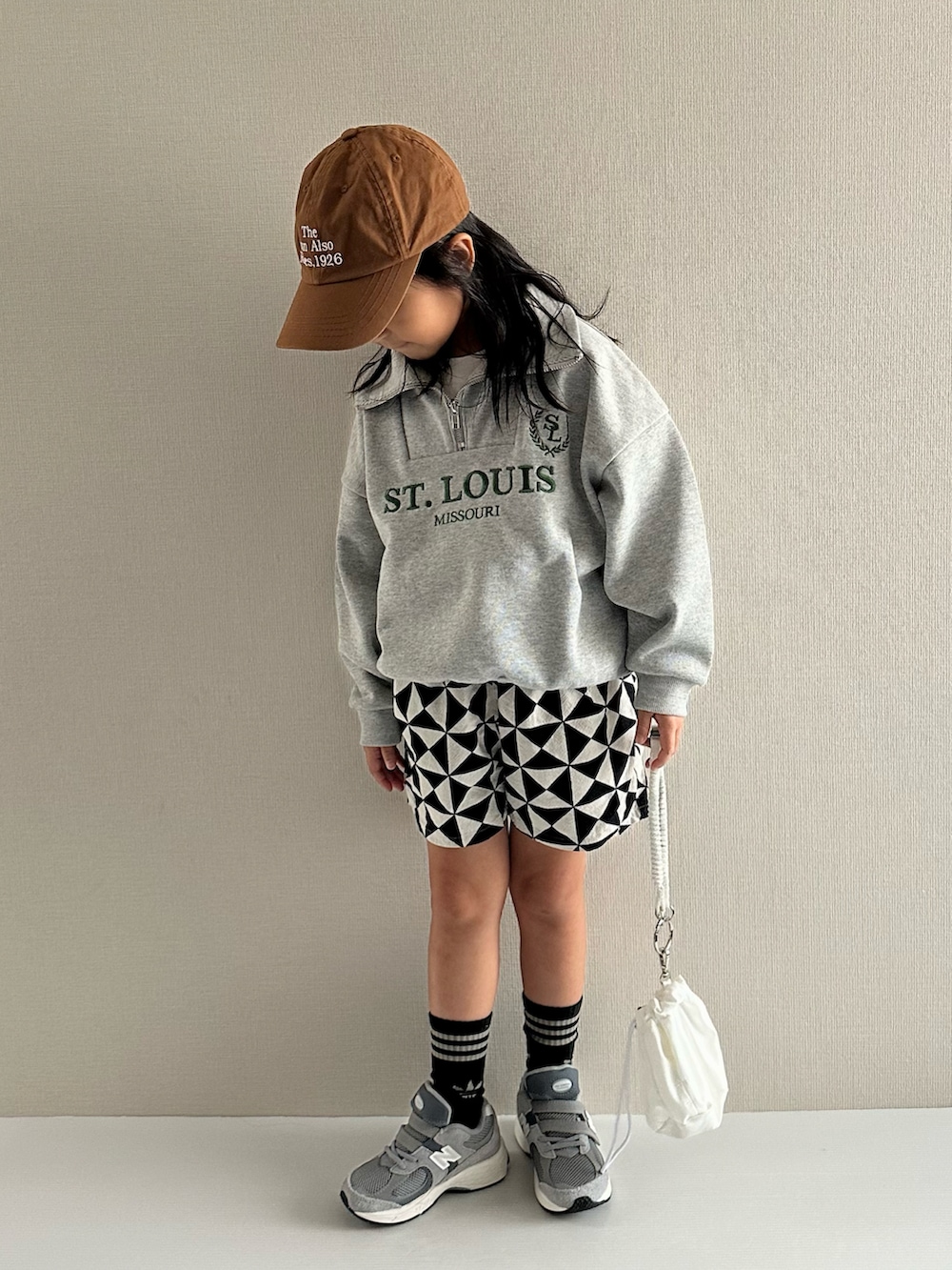 グレー系のスウェット、グレー系のその他パンツ、ホワイト系のショルダーバッグを着用したキッズの秋コーディネートの5枚目の写真