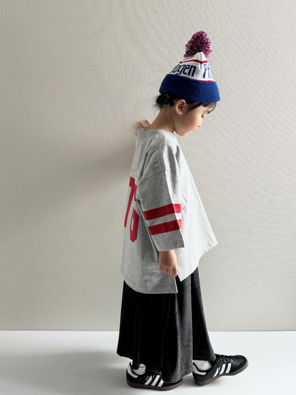 グレー系のTシャツ/カットソー、ブラック系のスカート、ブラック系のスニーカーを着用したキッズの冬コーディネートの2枚目の写真