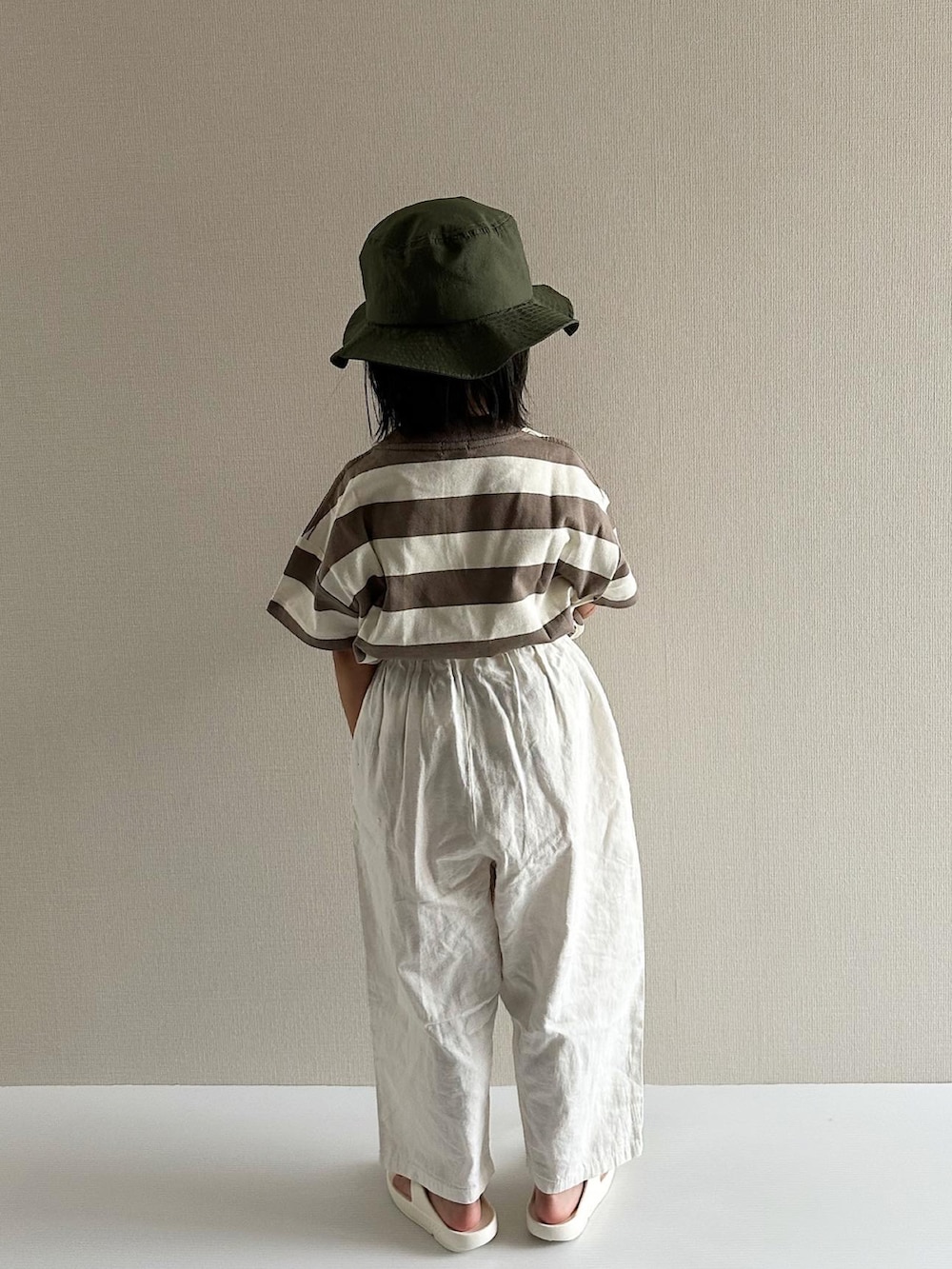 ブラウン系のTシャツ/カットソー、ホワイト系のパンツ、ホワイト系のサンダルを着用したキッズの夏コーディネートの4枚目の写真