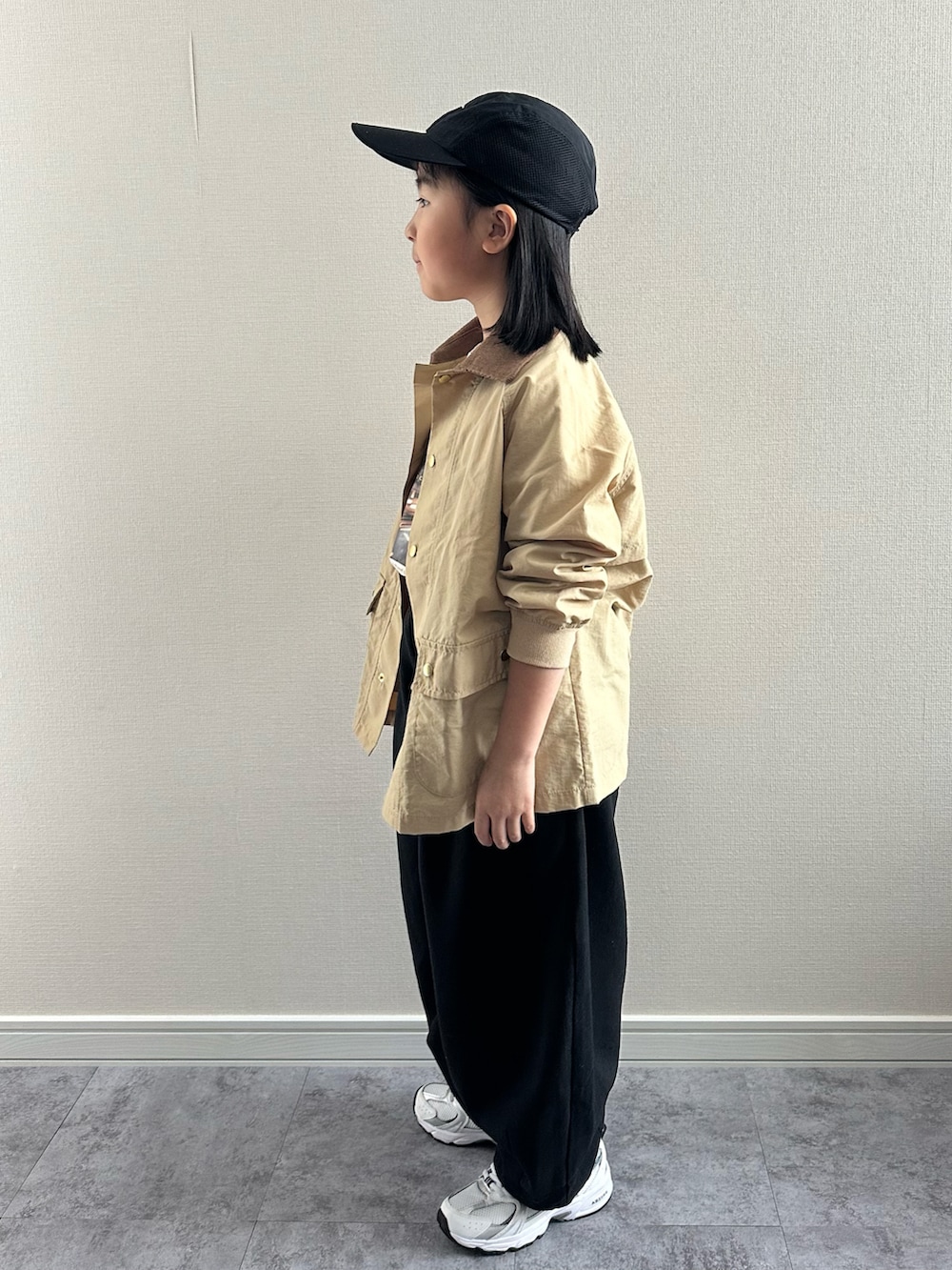 ベージュ系のTシャツ/カットソー、ベージュ系のナイロンジャケット、ブラック系のその他パンツを着用したキッズの春コーディネートの2枚目の写真