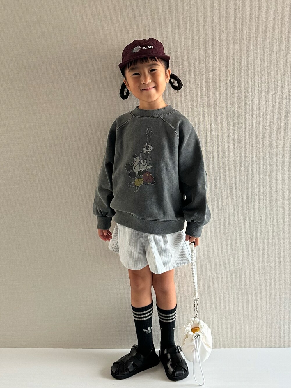 グレー系のスウェット、ブルー系のパンツ、ホワイト系のショルダーバッグを着用したキッズの秋コーディネートの5枚目の写真