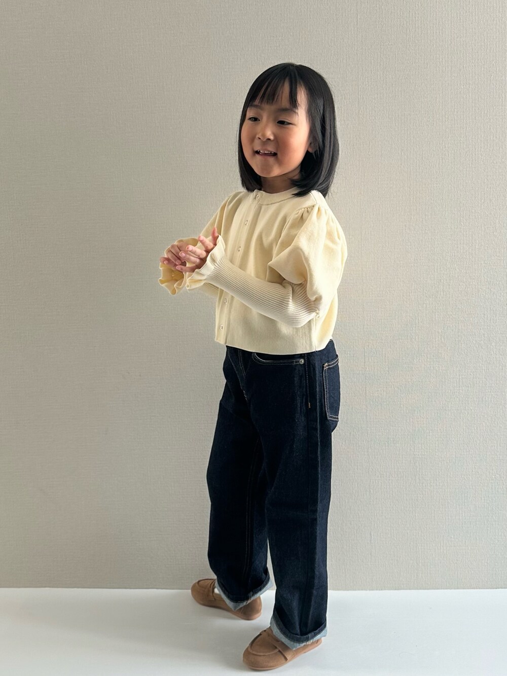 ホワイト系のカーディガン/ボレロ、ブルー系のデニムパンツ、ブラウン系のローファーを着用したキッズの冬コーディネートの4枚目の写真