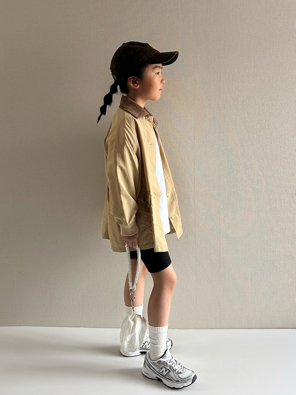 ベージュ系のナイロンジャケット、ホワイト系のTシャツ/カットソー、ブラック系のその他パンツを着用したキッズの春コーディネートの4枚目の写真