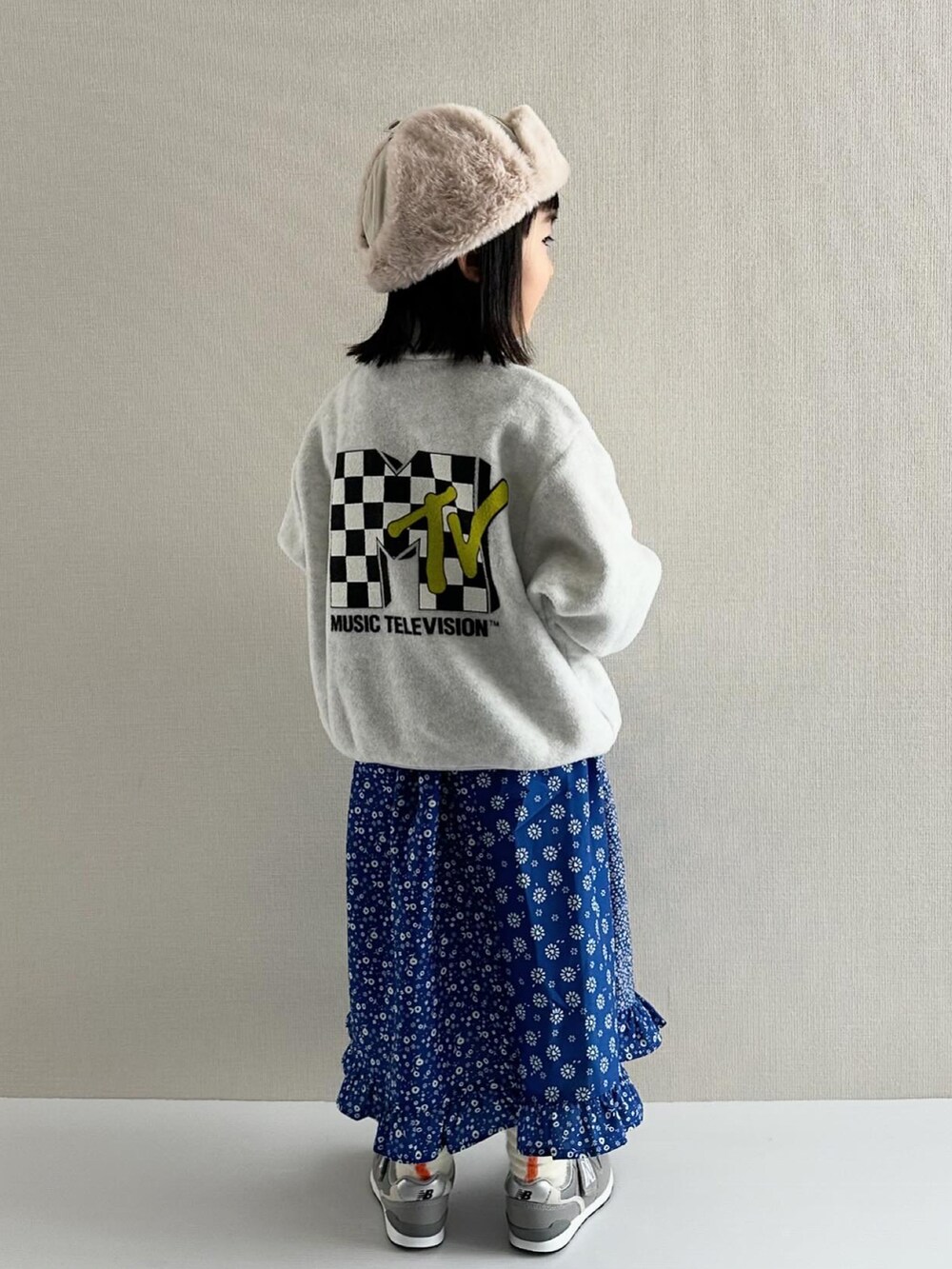 ホワイト系のパーカー、ブルー系のワンピース、グレー系のスニーカーを着用したキッズの冬コーディネートの2枚目の写真