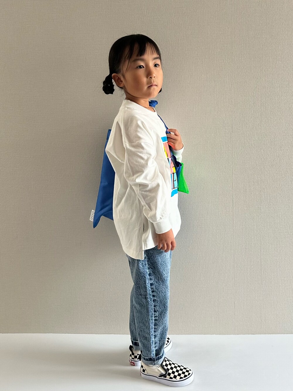 ホワイト系のTシャツ/カットソー、ブルー系のデニムパンツ、ブルー系のトートバッグを着用したキッズの秋コーディネートの5枚目の写真