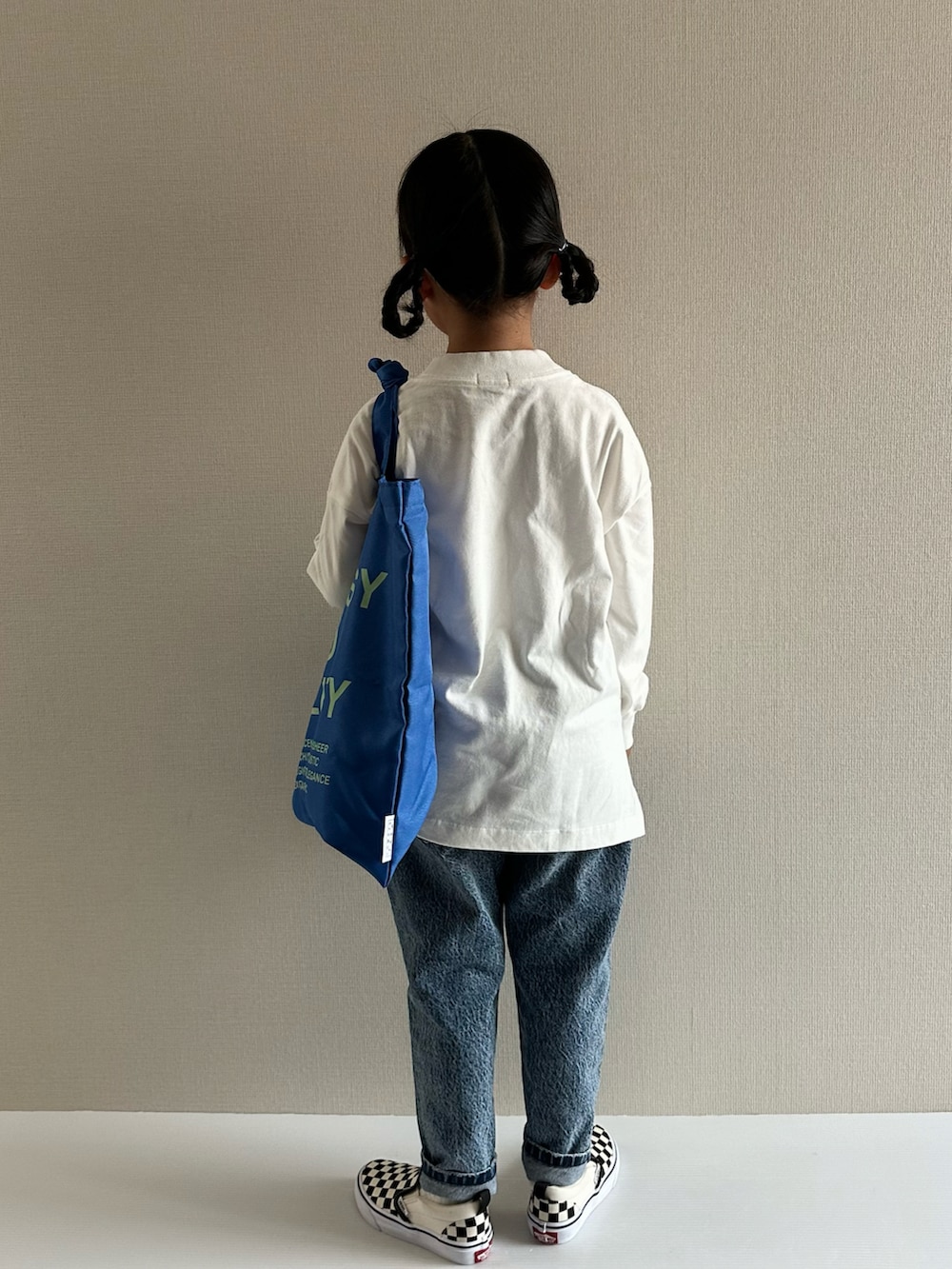 ホワイト系のTシャツ/カットソー、ブルー系のデニムパンツ、ブルー系のトートバッグを着用したキッズの秋コーディネートの4枚目の写真