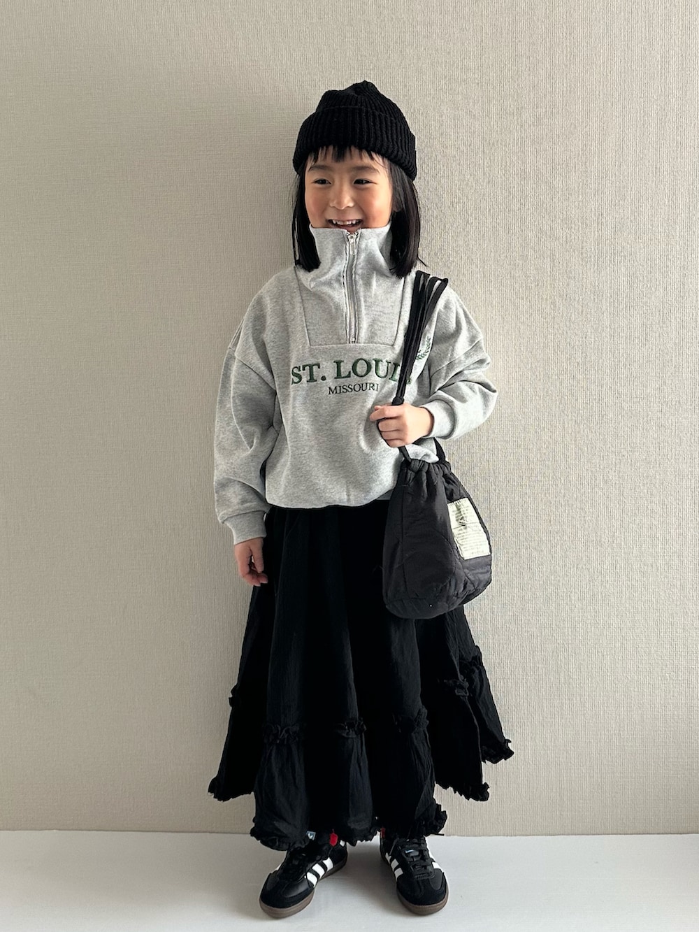 グレー系のスウェット、ブラック系のスカート、ブラック系のショルダーバッグを着用したキッズの冬コーディネートの5枚目の写真