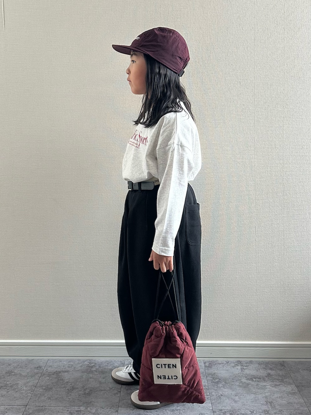 グレー系のTシャツ/カットソー、ブラック系のその他パンツ、レッド系のショルダーバッグを着用したキッズの秋コーディネートの4枚目の写真