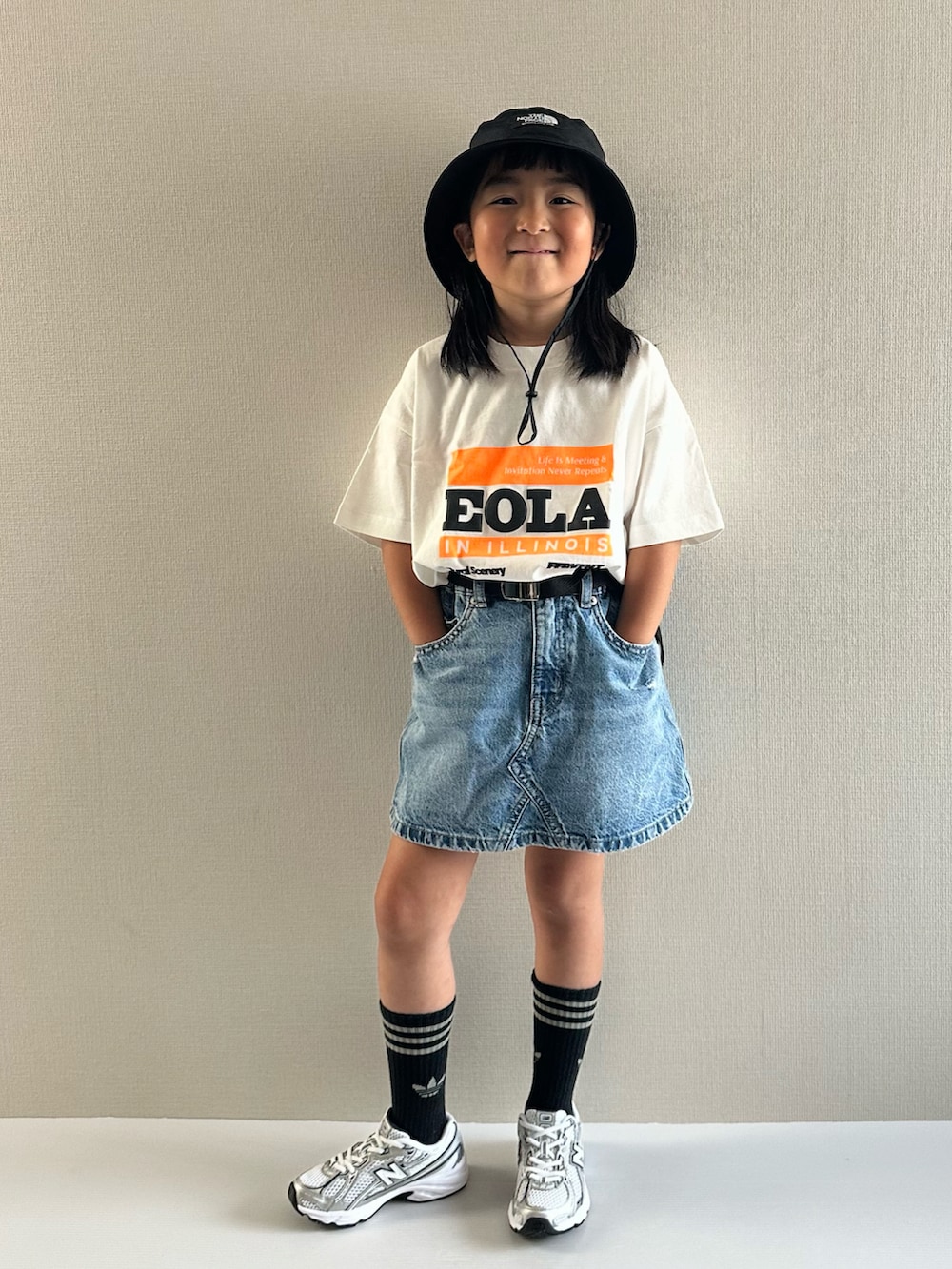 ホワイト系のTシャツ/カットソー、ブルー系のデニムスカート、ホワイト系のスニーカーを着用したキッズの夏コーディネートの5枚目の写真