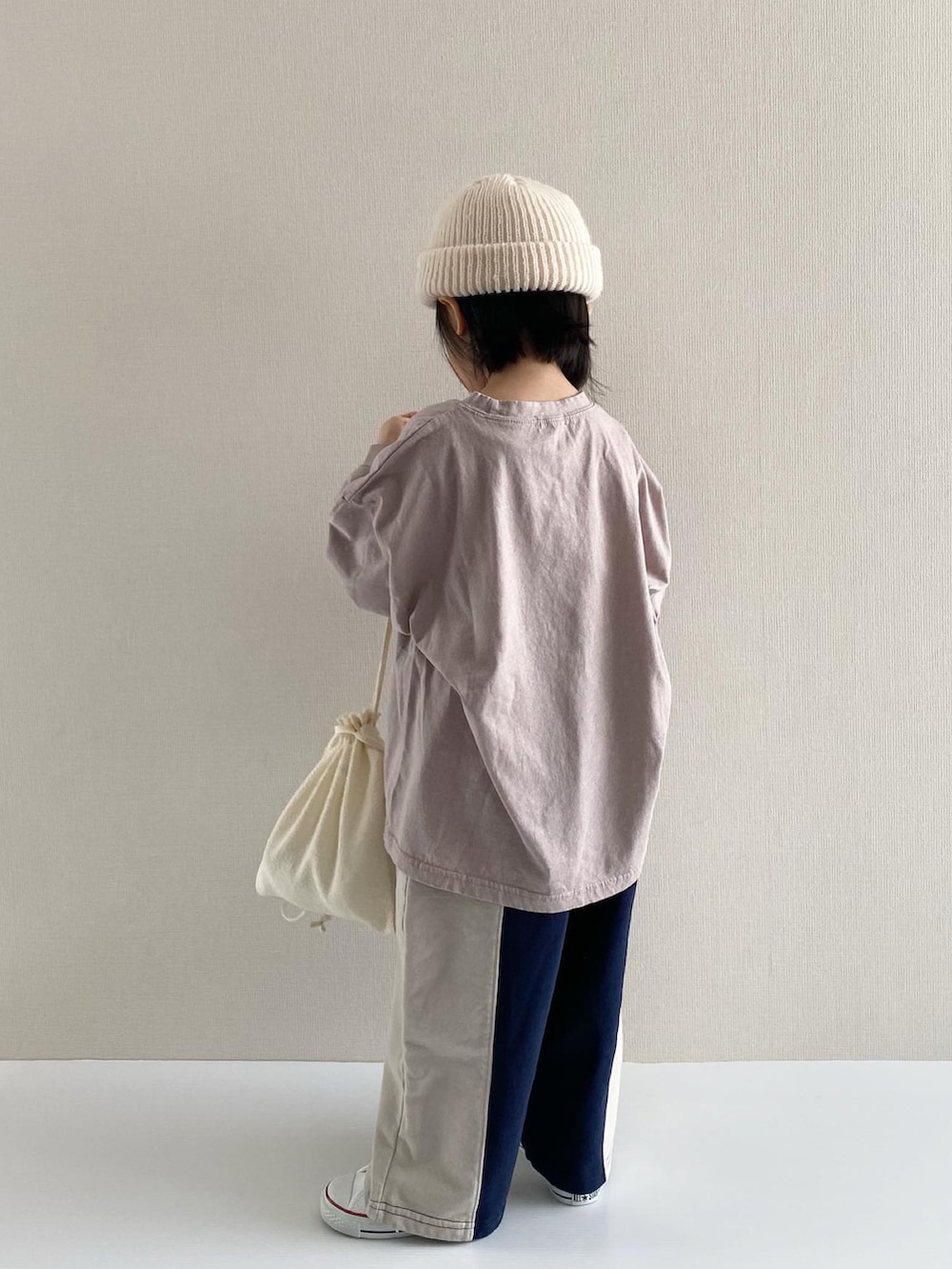 パープル系のTシャツ/カットソー、ブルー系のパンツ、ホワイト系のスニーカーを着用したキッズの冬コーディネートの4枚目の写真