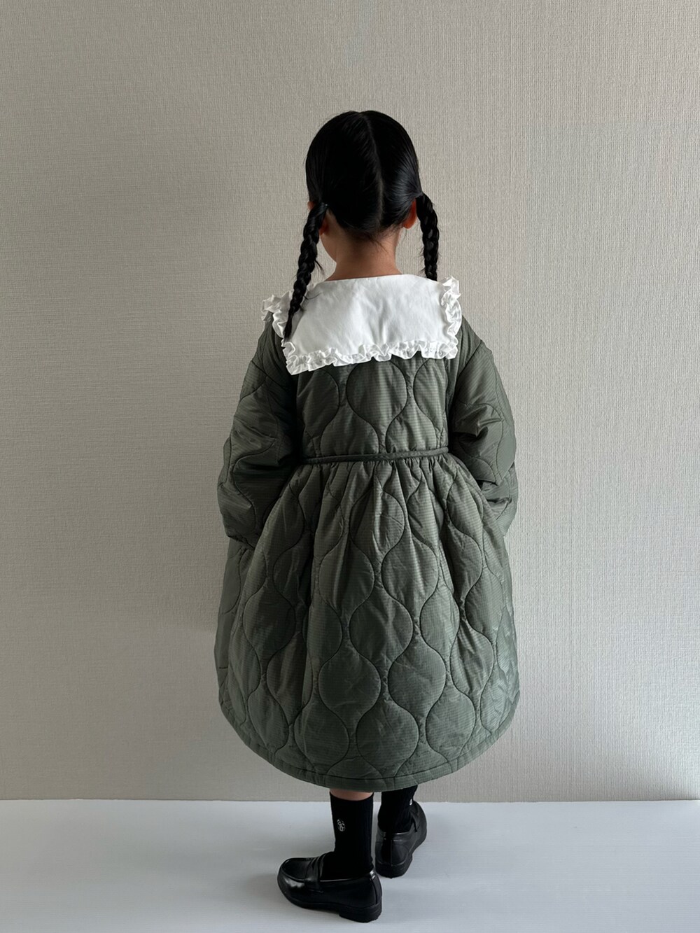 グリーン系のミリタリージャケット、ホワイト系のシャツ/ブラウス、ブラック系のローファーを着用したキッズの秋コーディネートの3枚目の写真