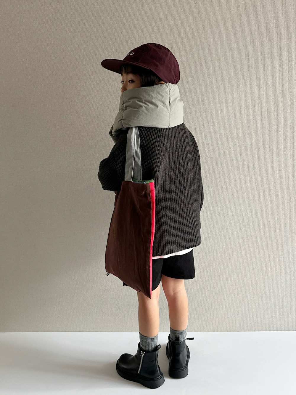 グレー系のニット/セーター、ブラック系のその他パンツ、ブラック系のブーツを着用したキッズの秋コーディネートの2枚目の写真