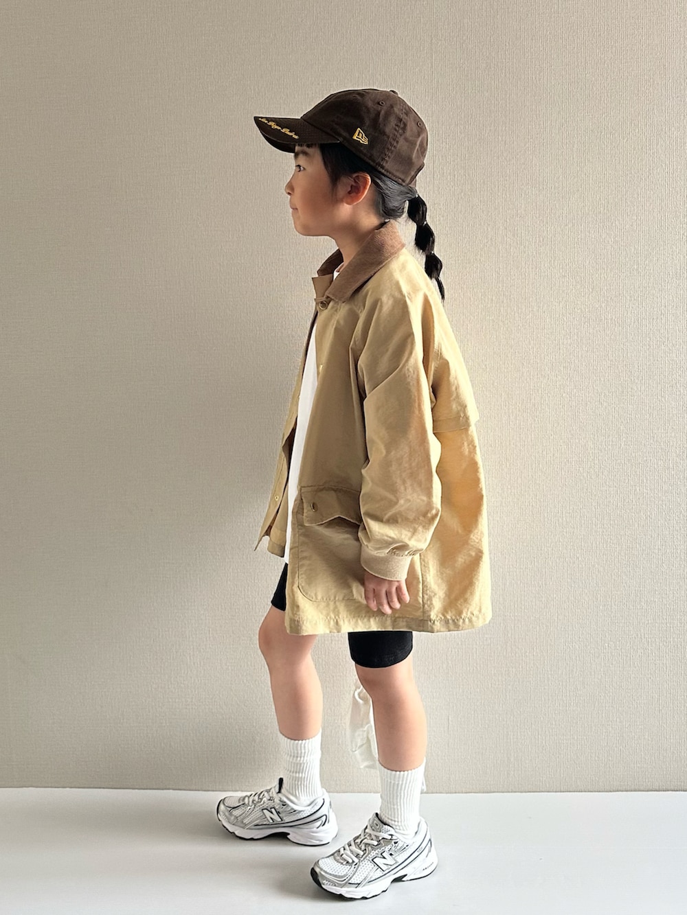 ベージュ系のナイロンジャケット、ホワイト系のTシャツ/カットソー、ブラック系のその他パンツを着用したキッズの春コーディネートの2枚目の写真