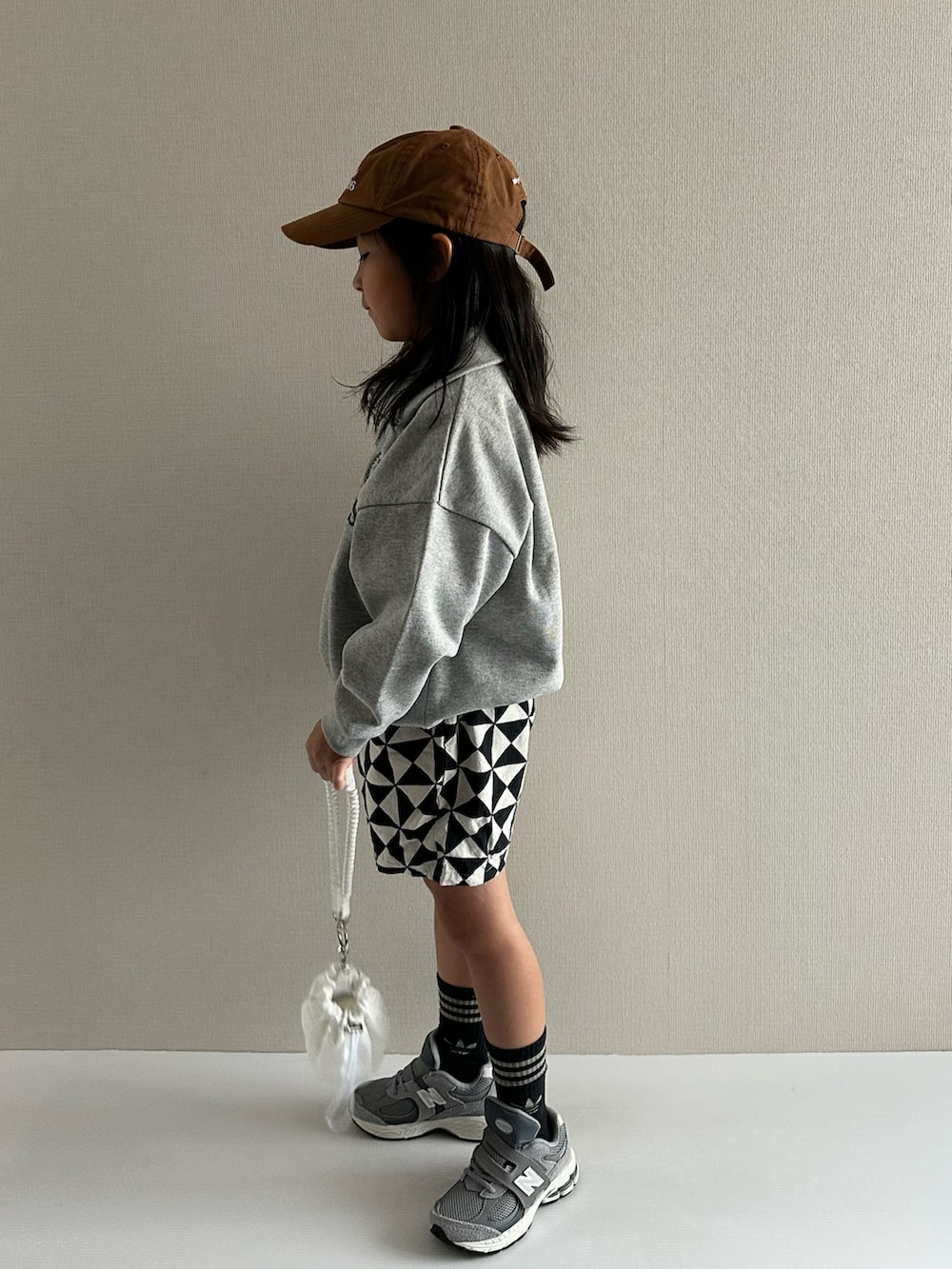 グレー系のスウェット、グレー系のその他パンツ、ホワイト系のショルダーバッグを着用したキッズの秋コーディネートの4枚目の写真