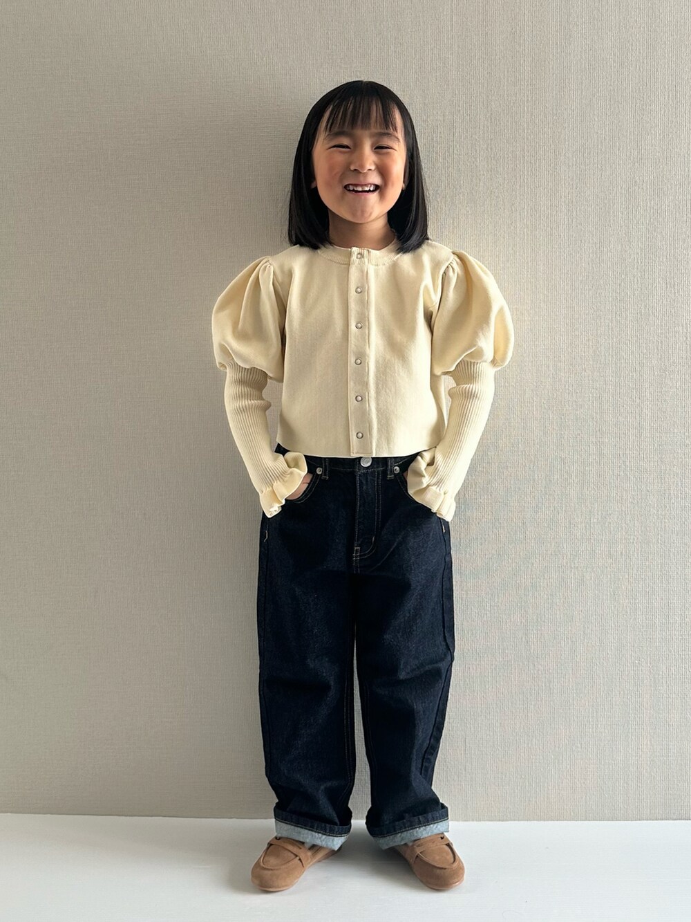 ホワイト系のカーディガン/ボレロ、ブルー系のデニムパンツ、ブラウン系のローファーを着用したキッズの冬コーディネートの5枚目の写真