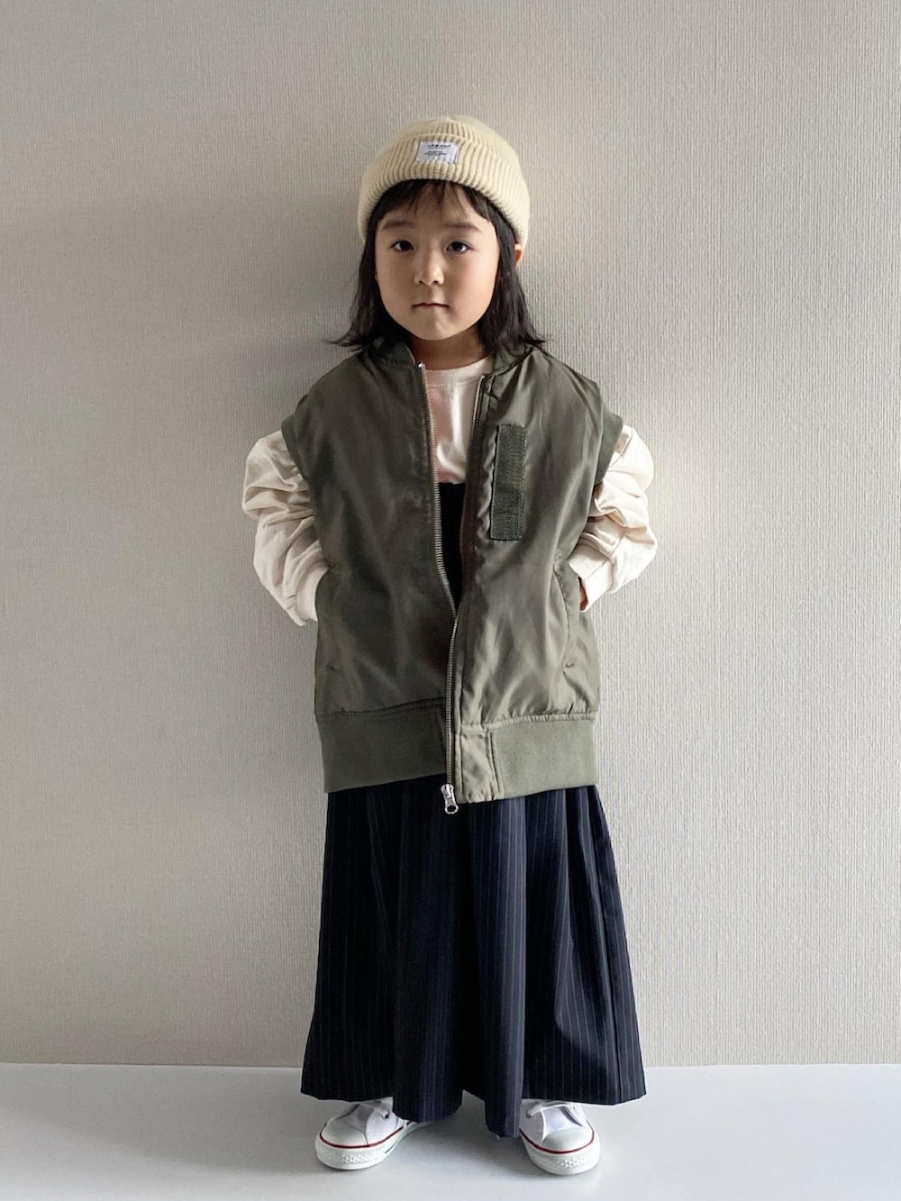 ブルー系のその他パンツ、グリーン系のダウンベスト、ホワイト系のスウェットを着用したキッズの秋コーディネートの5枚目の写真