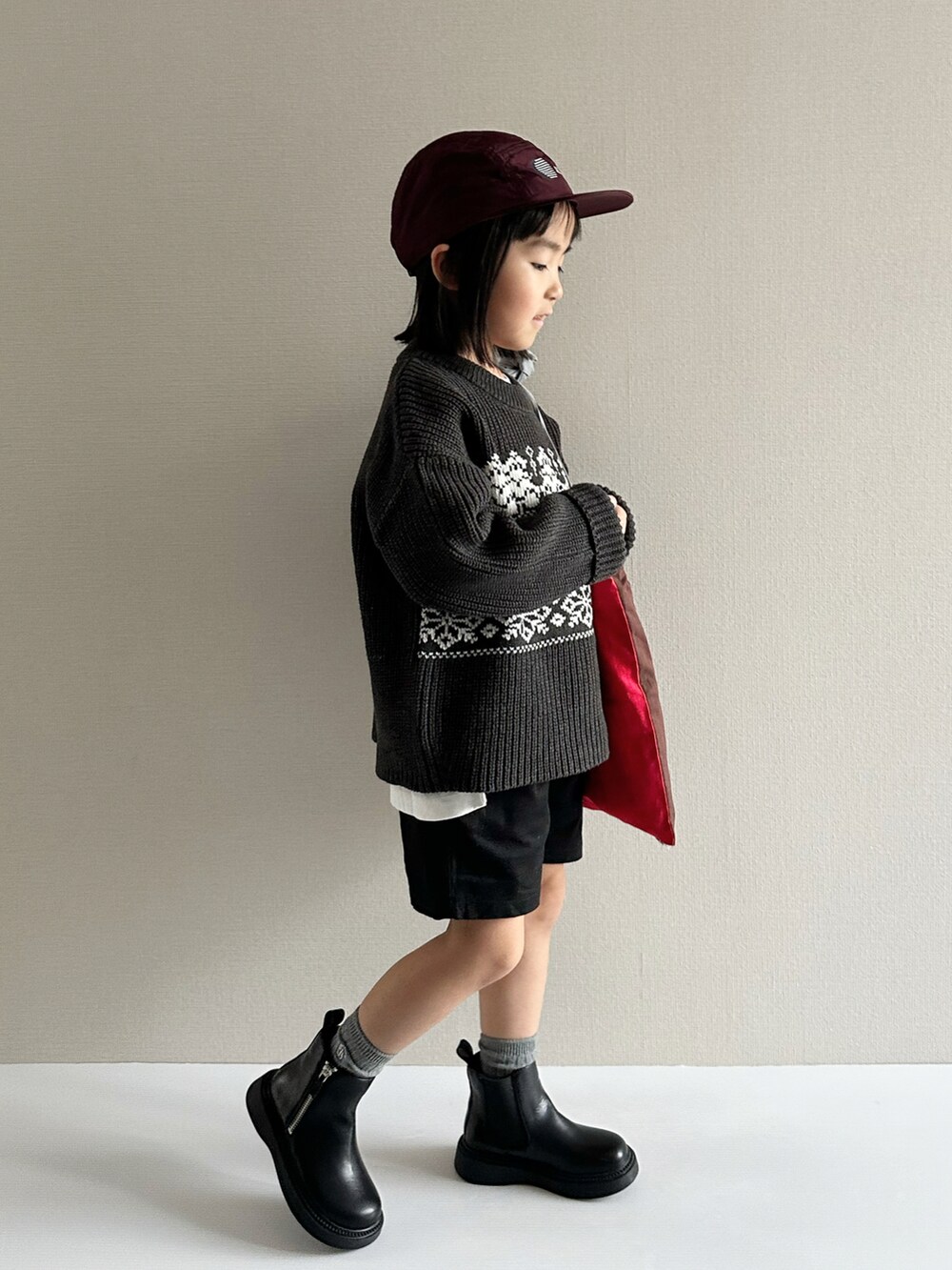 グレー系のニット/セーター、ブラック系のその他パンツ、ブラック系のブーツを着用したキッズの秋コーディネートの4枚目の写真