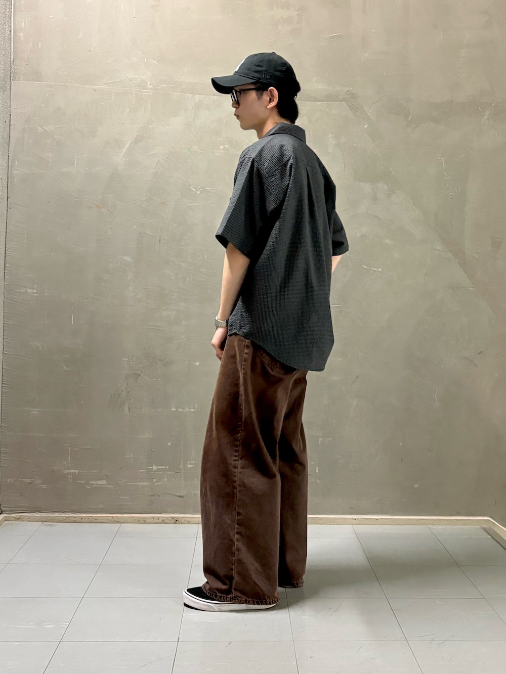 グレー系のシャツ/ブラウス、グレー系のTシャツ/カットソー、ブラック系のスニーカーを着用したメンズの夏コーディネートの2枚目の写真