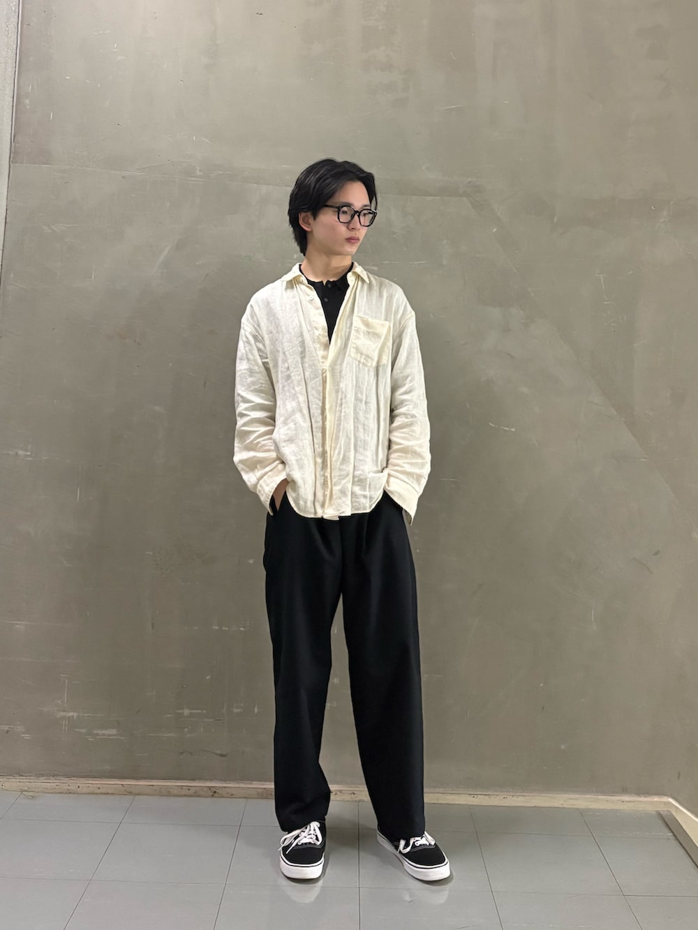 ブラック系のニット/セーター、ブラック系のその他パンツ、ブラック系のスニーカーを着用したメンズの春コーディネートの3枚目の写真