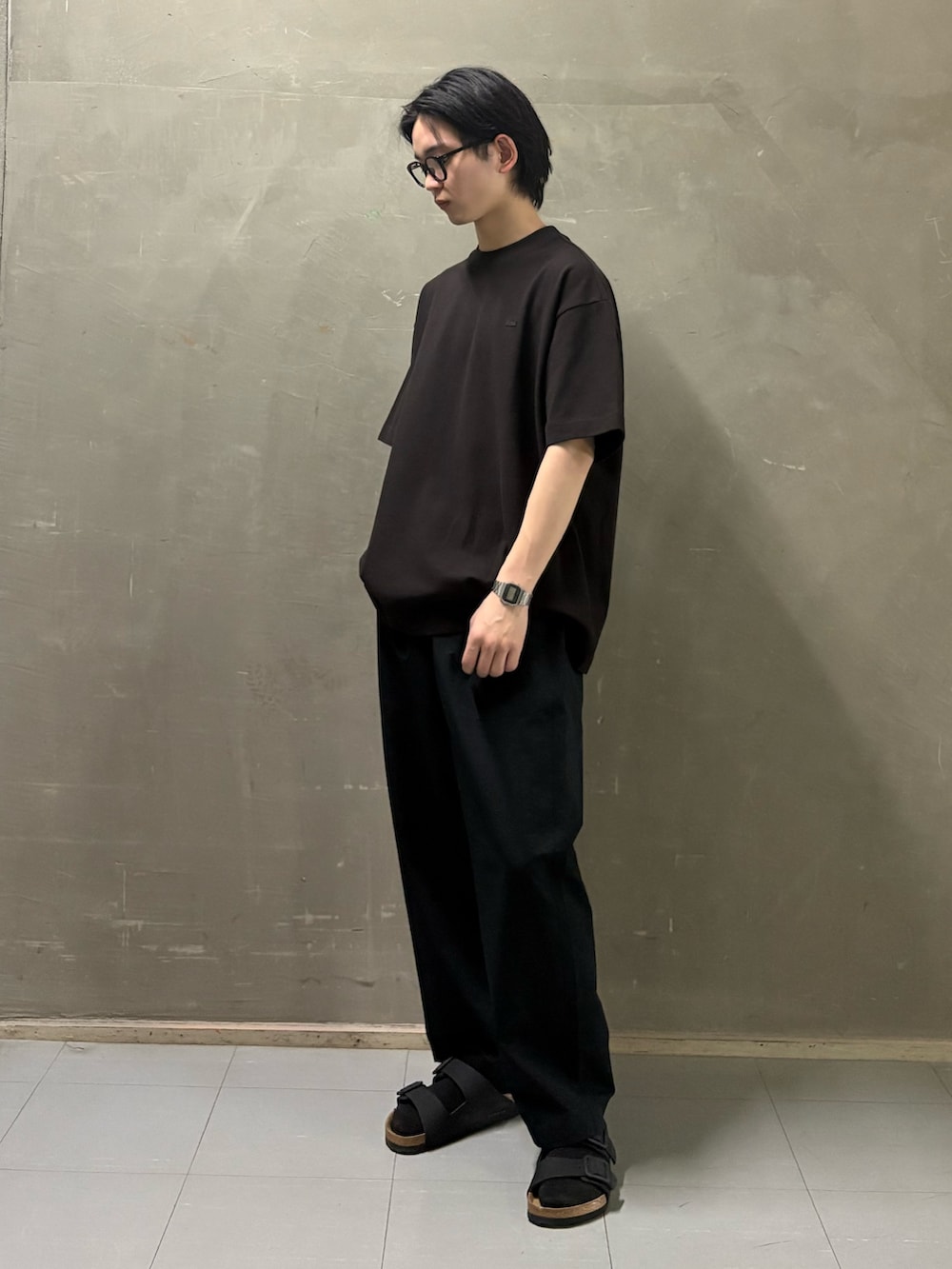 ブラウン系のTシャツ/カットソー、ブラック系のその他パンツ、ブラック系のサンダルを着用したメンズの春コーディネートの2枚目の写真