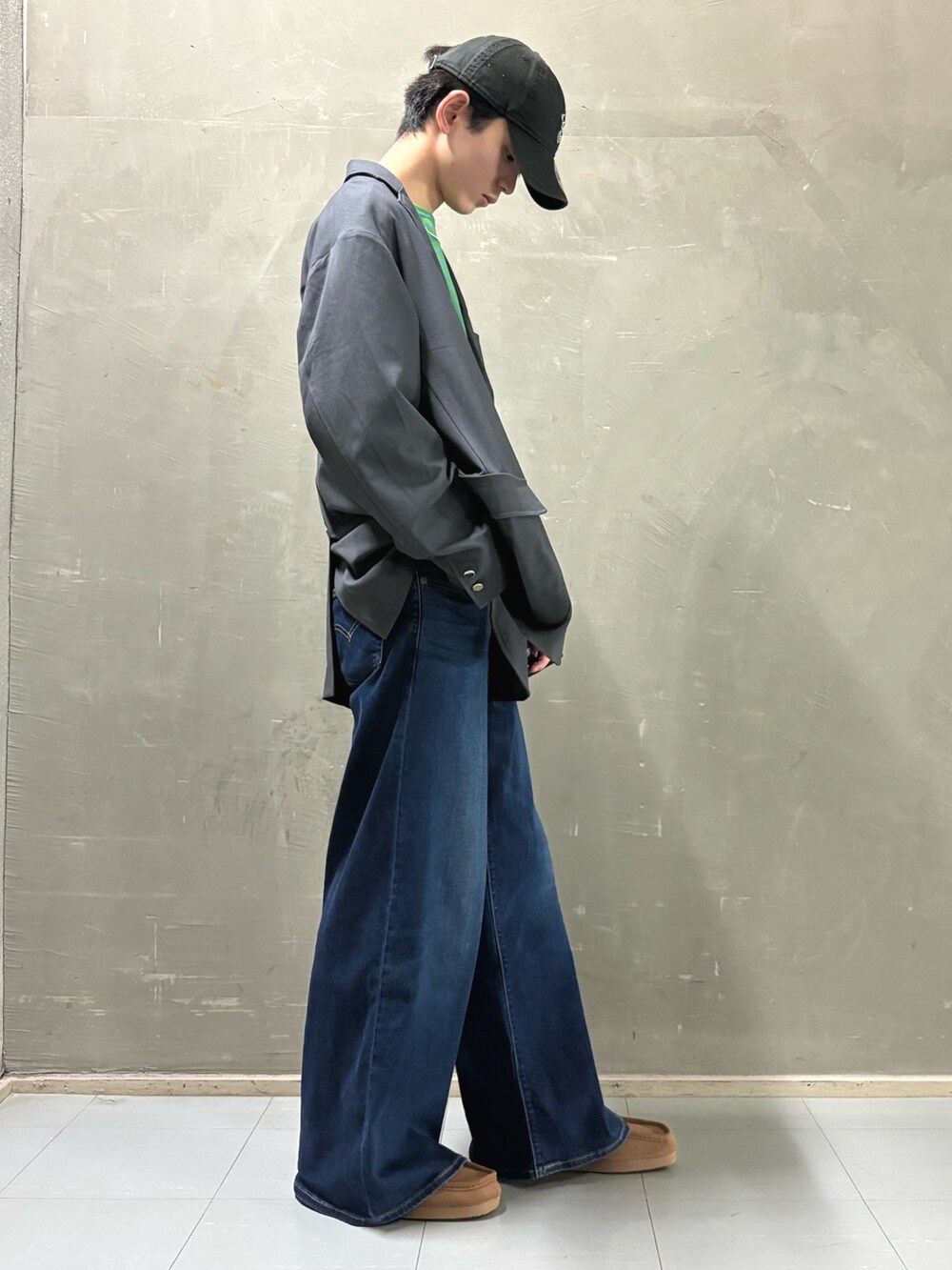 グレー系のその他アウター、グリーン系のTシャツ/カットソー、ブラウン系のブーツを着用したメンズの秋コーディネートの2枚目の写真