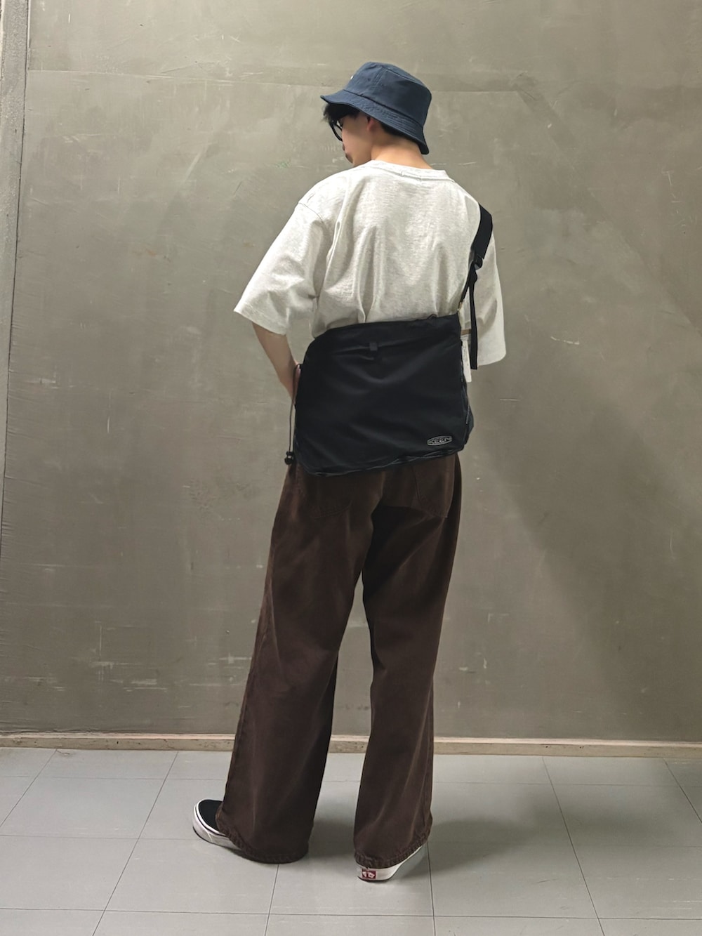 グレー系のTシャツ/カットソー、ブラック系のスニーカー、ブルー系のハットを着用したメンズの春コーディネートの2枚目の写真