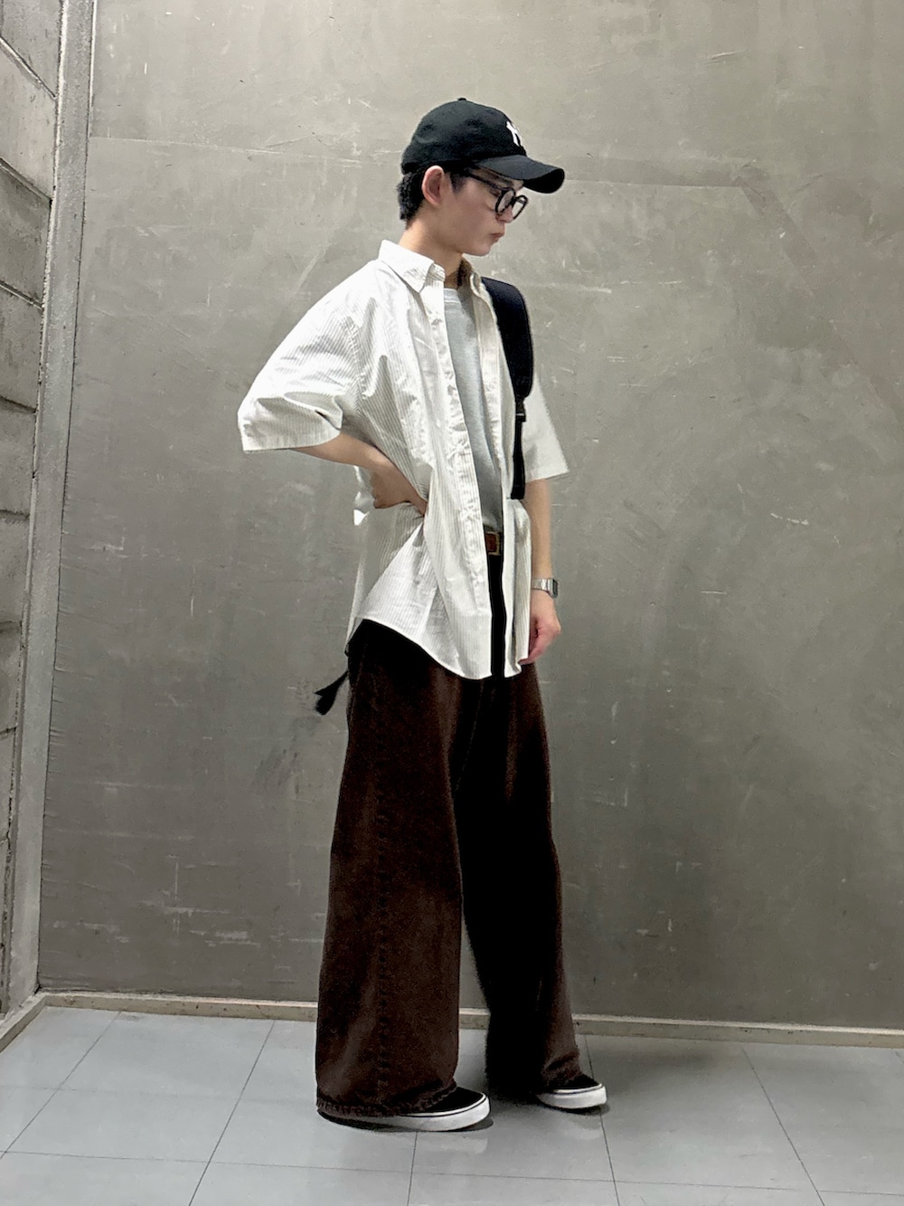 グレー系のTシャツ/カットソー、ブラック系のスニーカー、ブラック系のショルダーバッグを着用したメンズの夏コーディネートの2枚目の写真