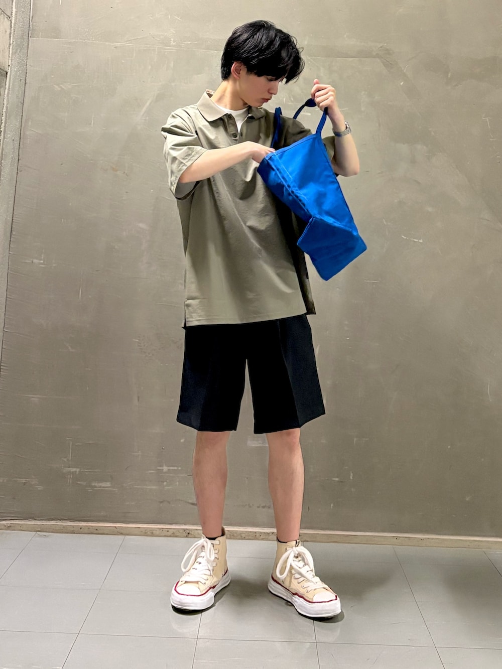 グリーン系のポロシャツ、ブルー系のその他パンツ、ブルー系のトートバッグを着用したメンズの夏コーディネートの2枚目の写真