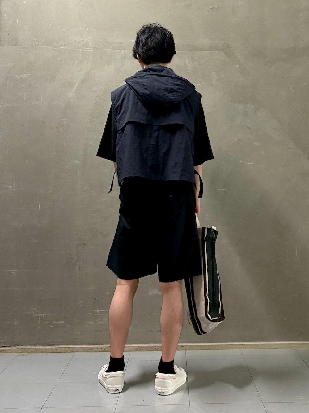 ブルー系のダウンベスト、ブラック系のTシャツ/カットソー、ブラック系のその他パンツを着用したメンズの夏コーディネートの2枚目の写真