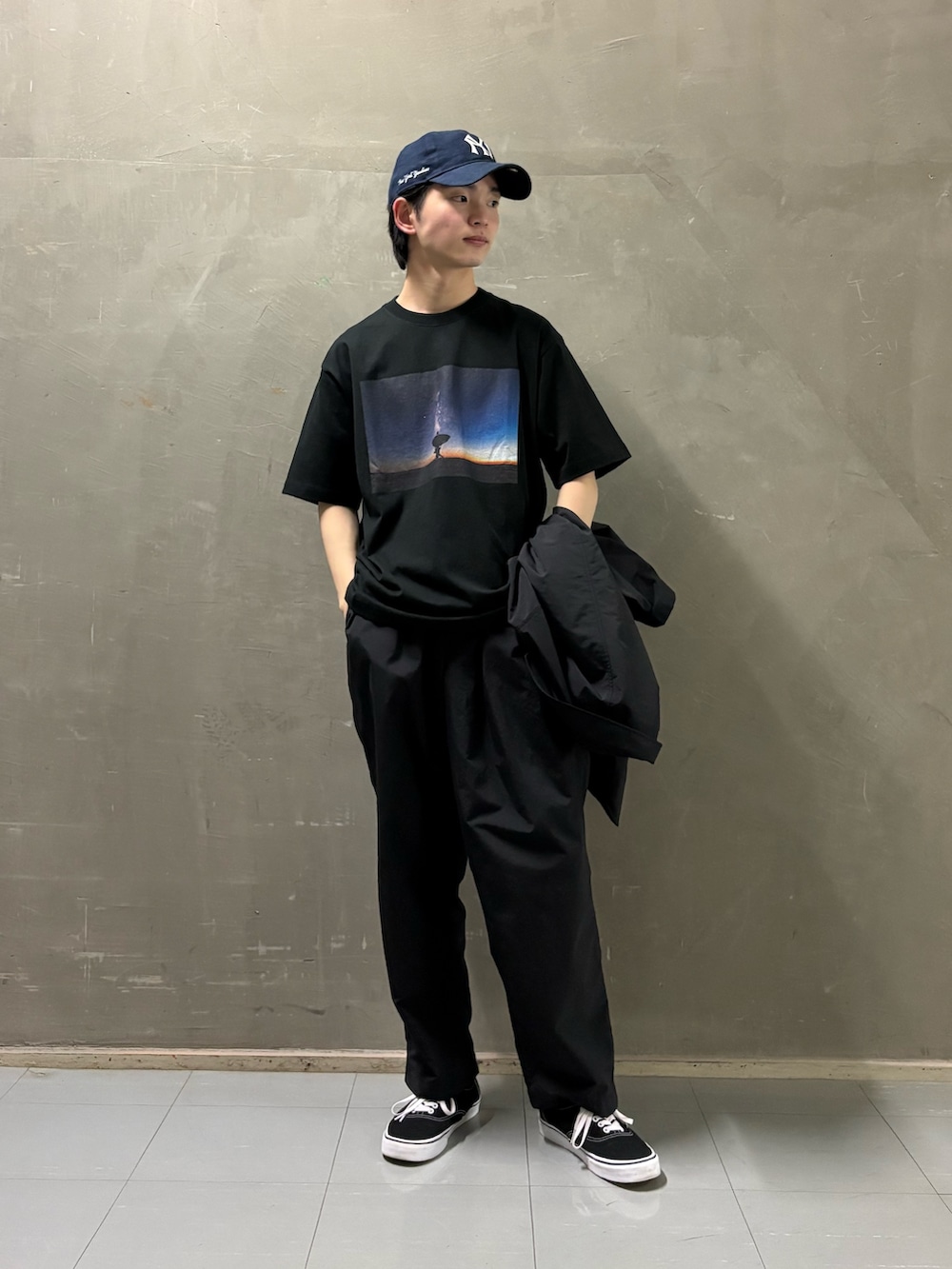 ブラック系のその他アウター、ブラック系のその他パンツ、ブラック系のTシャツ/カットソーを着用したメンズの春コーディネートの2枚目の写真