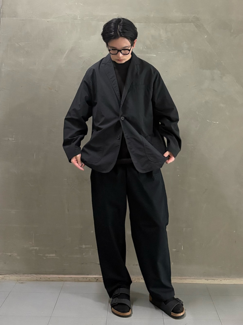 ブラウン系のTシャツ/カットソー、ブラック系のその他パンツ、ブラック系のサンダルを着用したメンズの春コーディネートの3枚目の写真