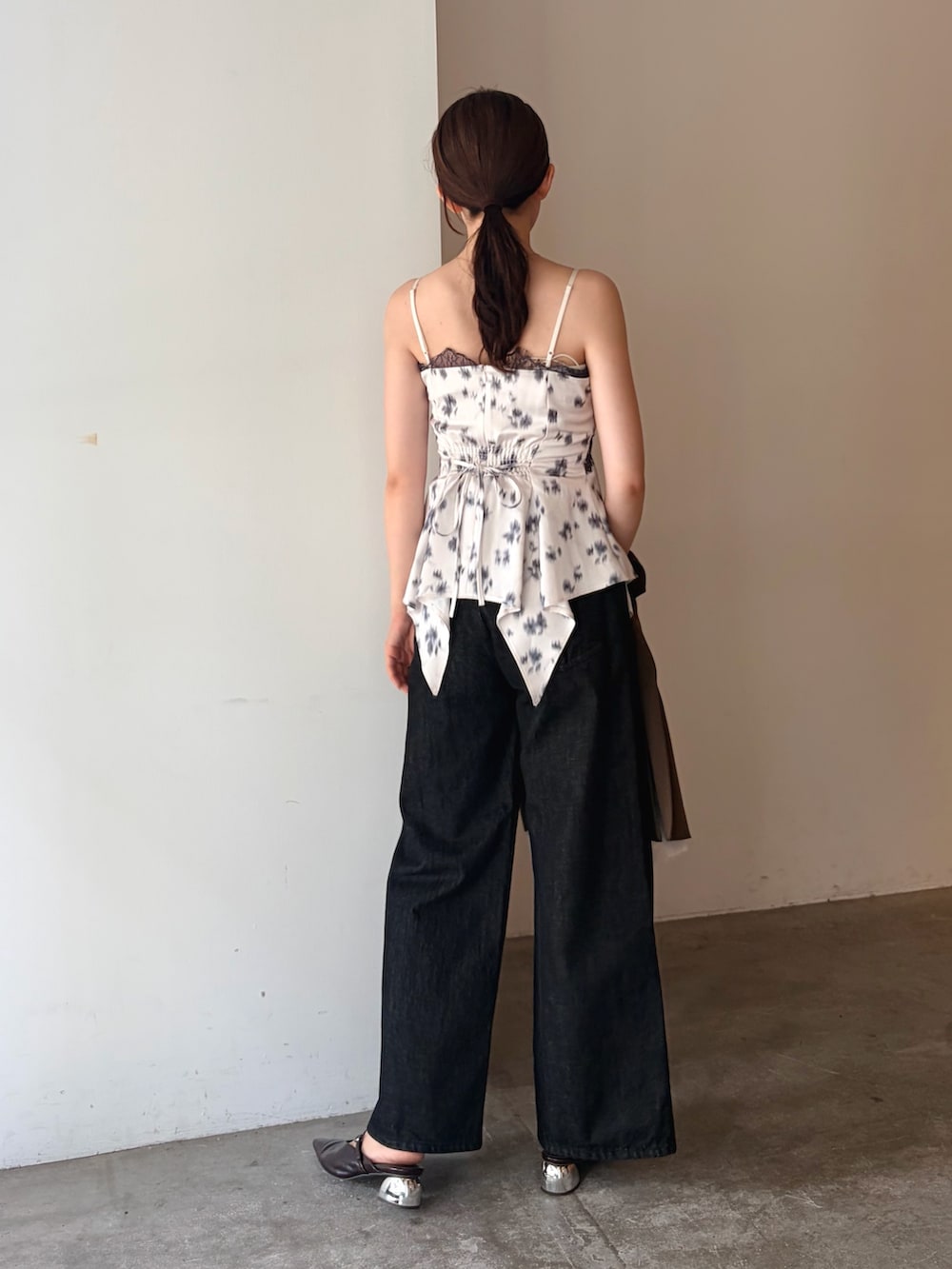 ブラック系のデニムパンツ、ブラウン系のテーラードジャケット、ホワイト系のキャミソールを着用したレディースの秋コーディネートの6枚目の写真
