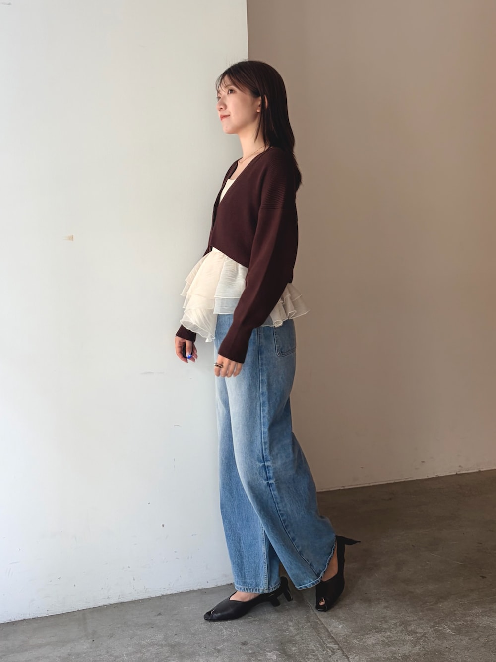 ブラウン系のカーディガン/ボレロ、ブルー系のデニムパンツ、ブラウン系のパンプスを着用したレディースの夏コーディネートの2枚目の写真