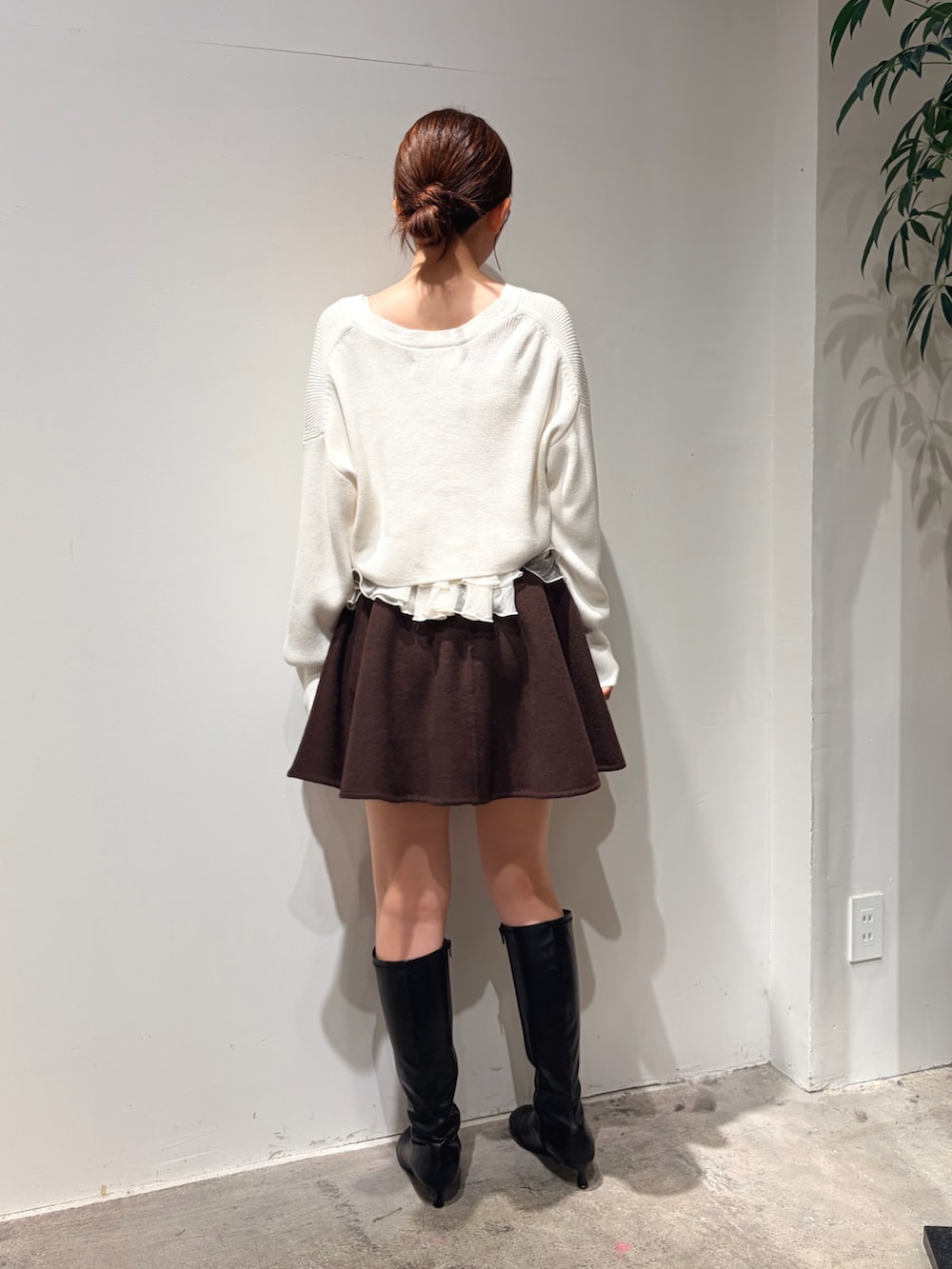 ホワイト系のカーディガン/ボレロ、ブラウン系のスカート、ブラック系のブーツを着用したレディースの秋コーディネートの3枚目の写真