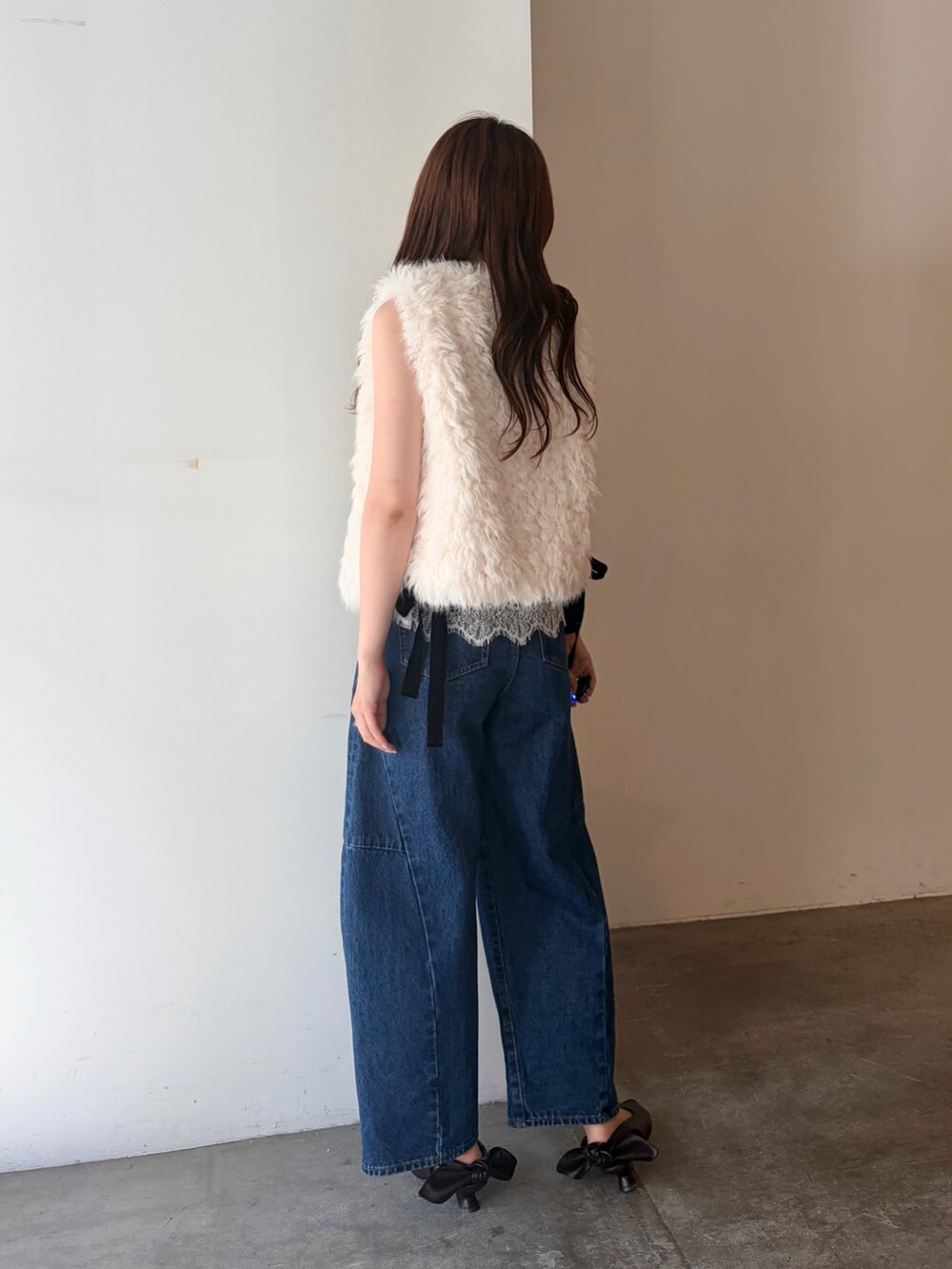 ホワイト系のベスト、ブラック系のTシャツ/カットソー、ブルー系のデニムパンツを着用したレディースの夏コーディネートの4枚目の写真