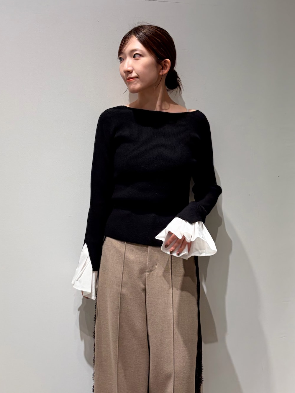 ホワイト系のチェスターコート、ベージュ系のその他パンツ、ブラック系のニット/セーターを着用したレディースの秋コーディネートの5枚目の写真