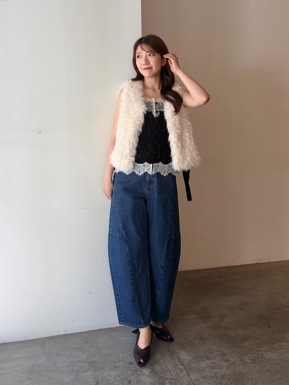 ホワイト系のベスト、ブラック系のTシャツ/カットソー、ブルー系のデニムパンツを着用したレディースの夏コーディネートの2枚目の写真