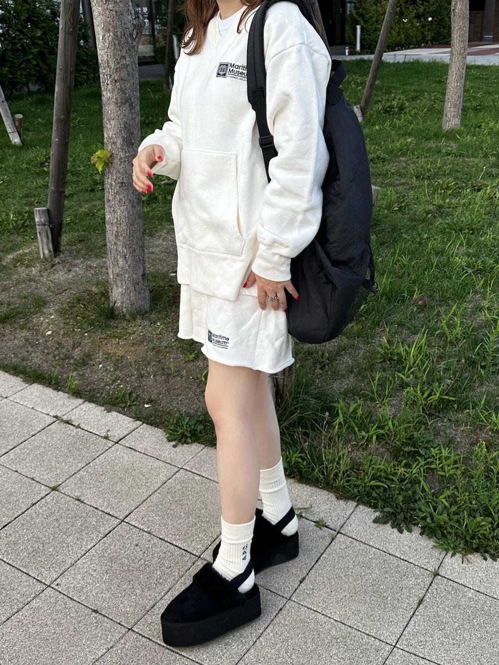 ホワイト系のスウェット、ホワイト系のスウェットパンツ、ブラック系のスリッポンを着用したレディースの秋コーディネートの2枚目の写真