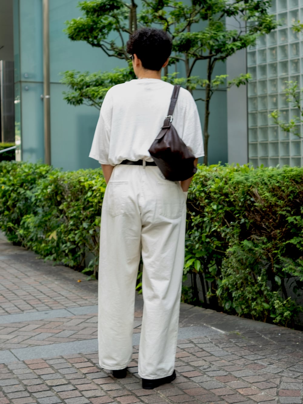 ブラック系のローファー、ホワイト系のTシャツ/カットソー、ホワイト系のデニムパンツを着用したメンズの夏コーディネートの2枚目の写真